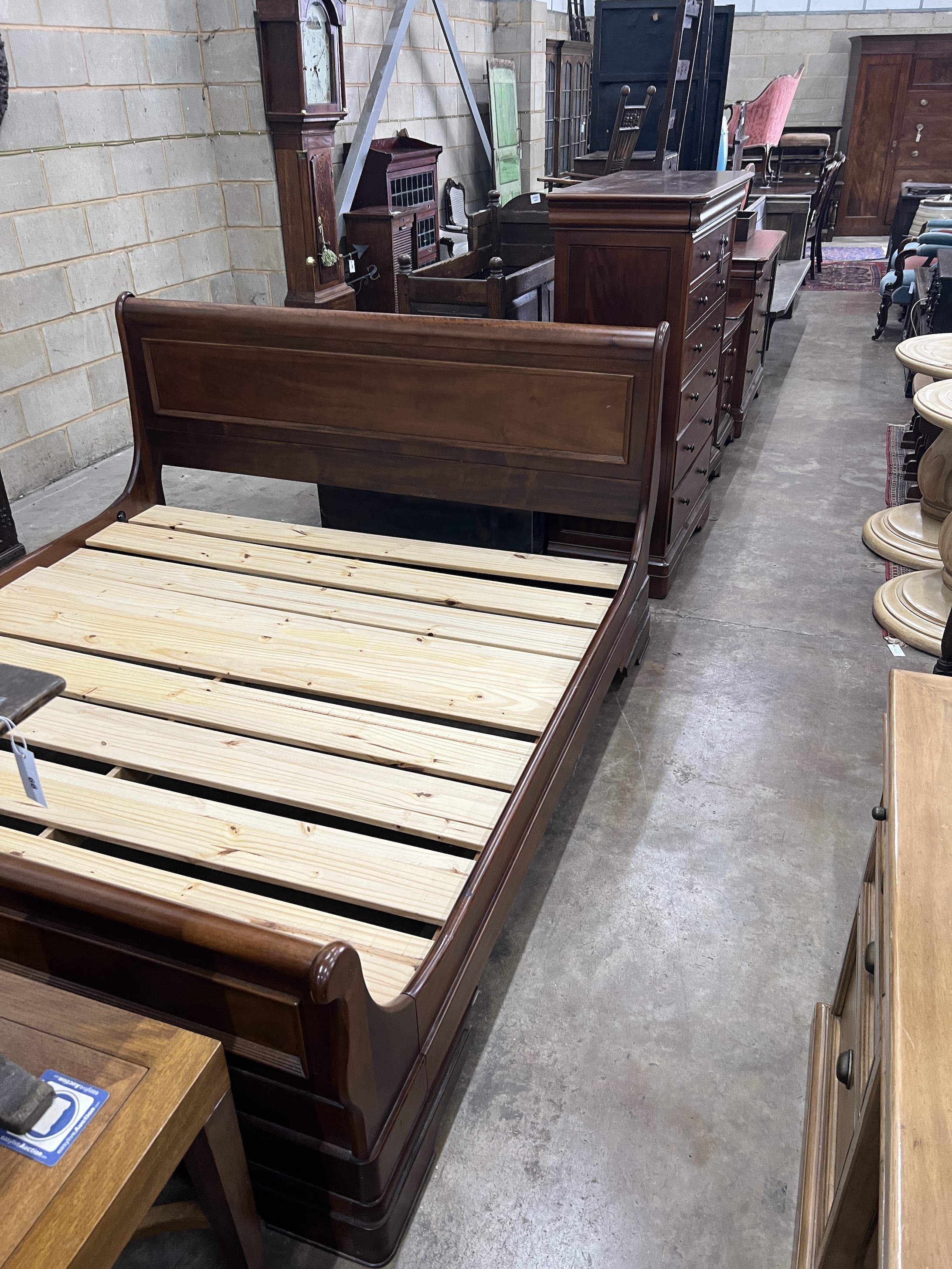 A contemporary five piece French mahogany bedroom suite, comprising sleigh bed, width 190cm, length 220cm, height 102cm (missing some bolts), a six drawer tall chest, three drawer chest and a pair of bedside chests